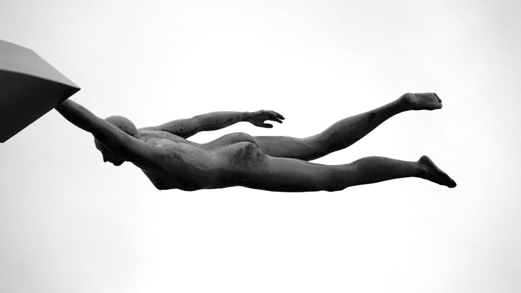 Greyscale Photography of Man Holding on White Building